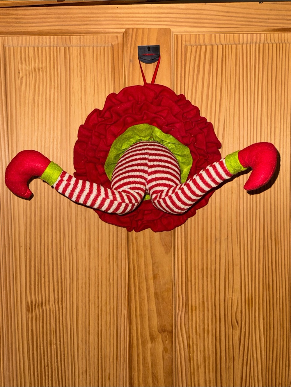 Creative elf leg climbs out of wreath look ultra-realistic and lifelike